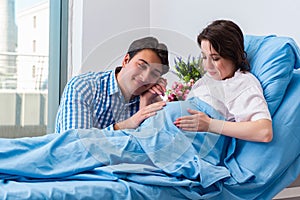 The caring loving husband visiting pregnant wife in hospital