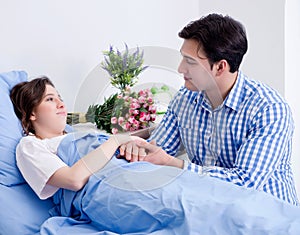 Caring loving husband visiting pregnant wife in hospital