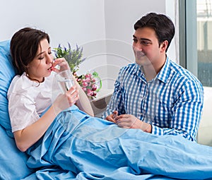 Caring loving husband visiting pregnant wife in hospital