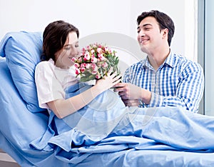 Caring loving husband visiting pregnant wife in hospital