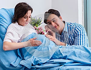 Caring loving husband visiting pregnant wife in hospital