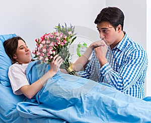 Caring loving husband visiting pregnant wife in hospital