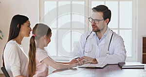 Caring male doctor talk stroking head of cute child girl