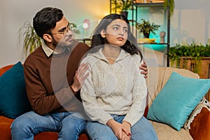 Caring man comforting upset Indian girlfriend supporting depressed woman because of bad day at home