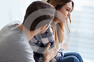 Caring man comforting upset wife after fight