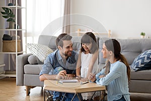 Caring mom and dad teaching little daughter to draw