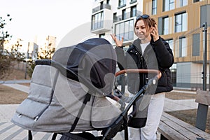 caring mom entertains her baby in a baby stroller