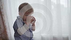 Caring mother gives her healthy male child a glass cup of clean drinking water