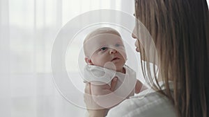 Caring mother kissing her newborn son at home