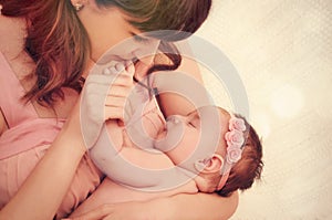 Caring mother kissing little fingers of her cute sleeping baby g photo