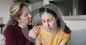 Caring mother talking to frustrated young adult daughter