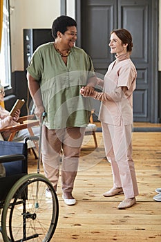Caring Nurse Helping Senior Woman in Retirement Home