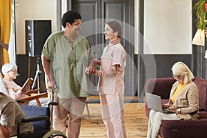 Caring Nurse Helping Seniors in Retirement Home