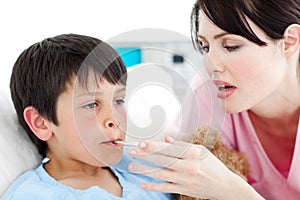 Caring nurse taking her patient's temperature