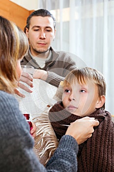 Caring parents giving medicinal sirup to son