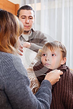 Caring parents giving medicinal sirup to teenage boy