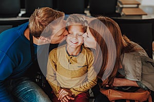 Caring parents are kissing their son in waiting hall