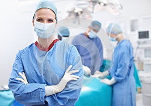 A caring profession. Portrait of a female doctor standing in an operating room wearing hosptial scrubs and gloves.