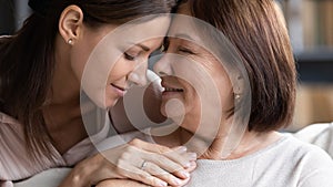 Caring senior mom and adult daughter hugging