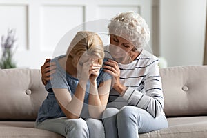 Caring senior mother comfort upset grownup daughter