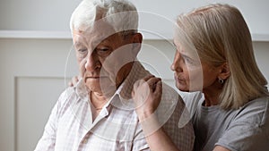 Caring senior wife hug comfort upset elderly husband