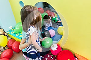 Caring teacher guiding a shy pre-school girl during playtime