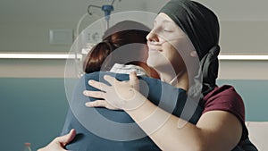 Caring woman hugging her friend with cancer at the hospital