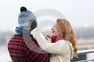 Caring woman putting warm hat on her husband