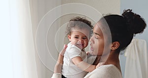 Caring young african american mother comforting crying infant baby.