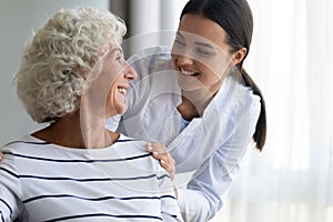 Caring young nurse assist handicapped mature female patient