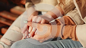Caring young woman holding hand supporting her friend and give empathy and support. Close up of female hands of two