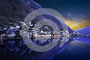 Carming alpine village of Hallstatt in the Austrian alps at night with stars in the sky