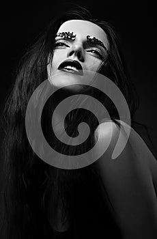 Carnality. Luxurious Woman Face with Strass over Black background photo