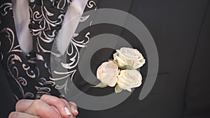 Carnation flower in a pocket. the flower in jacket pocket. pin with decorative white flowers pinned on the groom`s