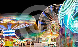 Carnival and Ferris Wheel at Night Spinning Lights