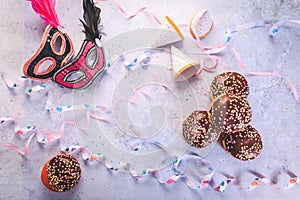 Carnival food. German Krapfen or donuts with streamers and confetti. Traditional Berliner for carnival and party