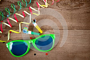 Carnival glasses and whistle on wood