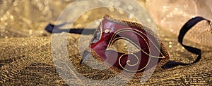 Carnival, mardi gras. Venetian handmade mask on gold shiny background, banner