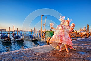 Carnival masks against gondolas in Venice, Italy