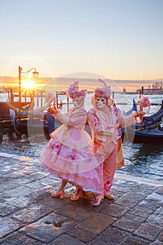 Carnival masks against gondolas in Venice, Italy