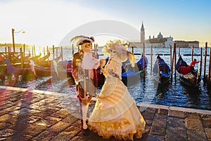 Carnival masks against gondolas in Venice, Italy