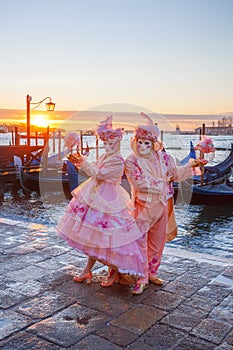 Carnival masks against gondolas in Venice, Italy