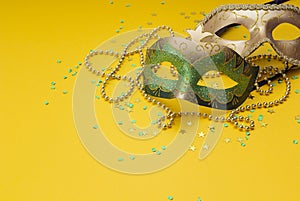Carnival masks and beads on a yellow background. Space for text.
