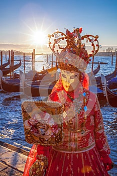 Carnival masks with mirror against gondolas in Venice, Italy