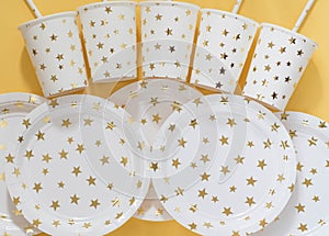 Carnival, paper holiday utensils with gold stars, yellow background and holiday eco-friendly utensils paper for przdel