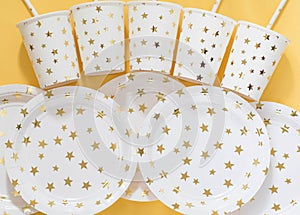 Carnival, paper holiday utensils with gold stars, yellow background and holiday eco-friendly utensils paper for przdel