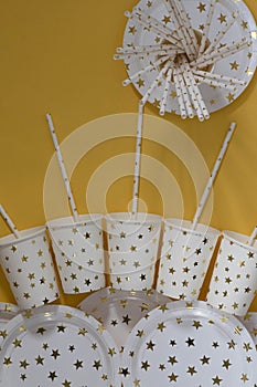 Carnival, paper holiday utensils with gold stars, yellow background and holiday eco-friendly utensils paper for przdel