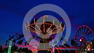 Carnival ride at the county fair with swing seats and spins at sunset