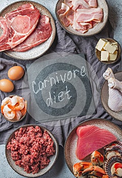 Carnivore diet concept. Raw ingredients for zero carb diet - fish, seafood, eggs, meat and animal fats. Top view or flat