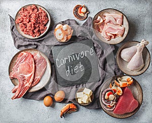 Carnivore diet concept. Raw ingredients for zero carb diet - fish, seafood, eggs, meat and animal fats. Top view or flat